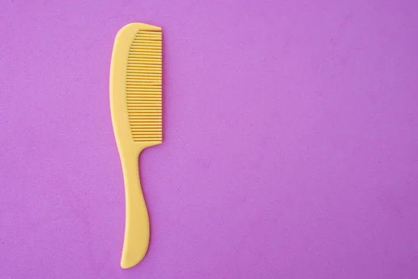 Çocuklar plastik saç tarağı sarı, pembe arka plan yakın plan