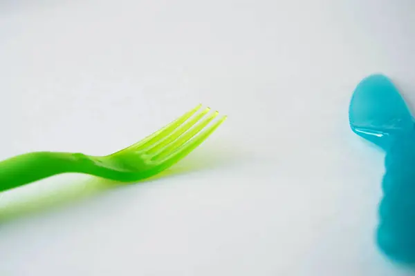 Plastik çatal yeşil ve bıçak mavi arka plan üst görünümü