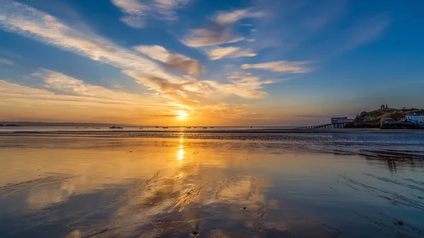 Reflexões do nascer do sol na maré baixa em Tenby, no País de Gales — Fotografia de Stock