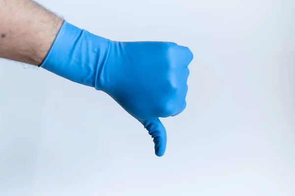 男性医師の手のジェスチャーは 医療青ニトリル手袋を着用して親指を示す 白を背景に フロントビュークローズアップ — ストック写真