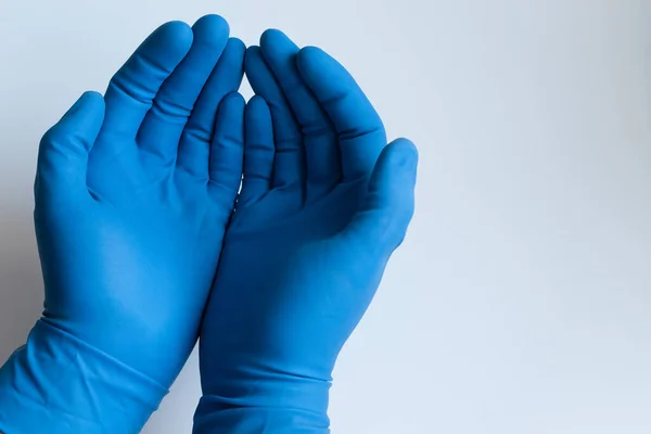 医師男性の手にニトリルブルーの医療用手袋何かを保持するように彼の手のひらを保持します 隔離された白い背景での閉鎖 — ストック写真