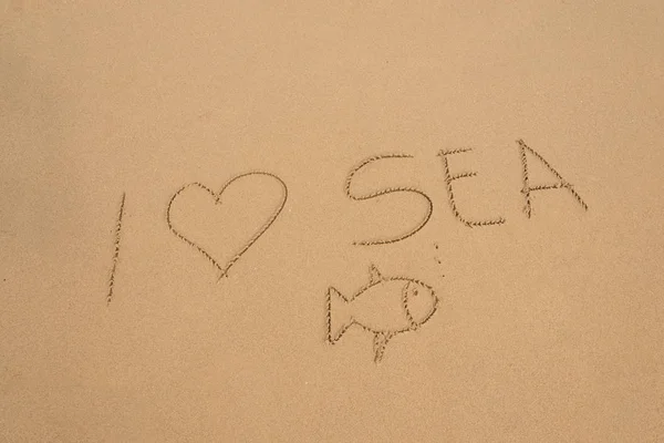Handwritten I love sea in the sand on the beach