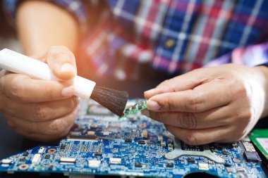 Asyalı teknisyen tamir ve temizlik kirli toz mikro devre ana bilgisayar elektronik teknolojisi fırça ile: donanım, cep telefonu, akıllı telefon, yükseltme konsepti