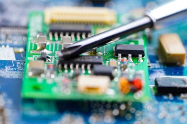 E-atık, sabit diskin içinde demir lehimleyerek onarılıyor. Bütünleşik devre. Veri, donanım, teknisyen ve teknoloji kavramı