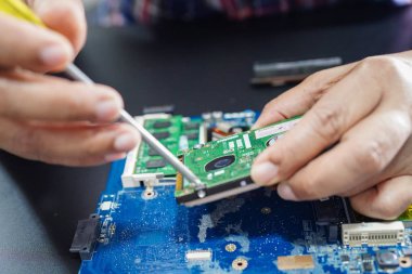 E-atık, sabit diskin içinde demir lehimleyerek tamir eden teknisyen. Bütünleşik devre. Veri, donanım, teknisyen ve teknoloji kavramı