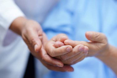 Asyalı yaşlı yaşlı ya da yaşlı kadın hasta tetik parmağı hemşire hastanesi koğuşunda yatarken elini kilitler: sağlıklı güçlü tıbbi konsept