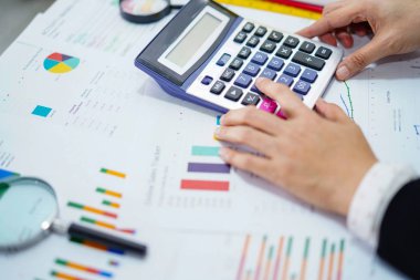 Muhasebeci basın hesap makinesi ve çalışma projesi modern ofiste grafikle muhasebe