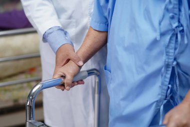 Doktor yardım ve bakım Asyalı yaşlı yaşlı ya da yaşlı kadın sağlıklı bir şekilde parkta yürürken yürüyüş yapıyor..