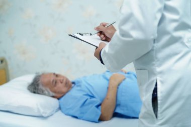 Asyalı yaşlı ya da yaşlı kadın hastane koğuşunda yatarken, doktor teşhisi panoya yazıyor: sağlıklı güçlü tıbbi konsept