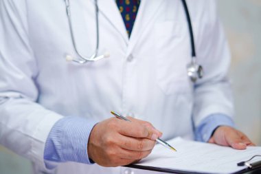 Steteskoplu doktor, hemşire hastanesi koğuşundaki hastaların teşhisi için panoya yazı yazıyor: sağlıklı güçlü tıbbi konsept.