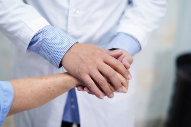 Dokunmadan eller Asya kıdemli veya yaşlı yaşlı kadın kadın hasta ile sevgi, bakım, yardım, teşvik tutan doktor ve hastane koğuşunda hemşirelik, empati: sağlıklı güçlü tıp kavramı 