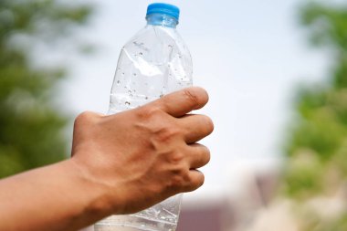 Boş su şişesini elle sıkıştır ve çöpe at..