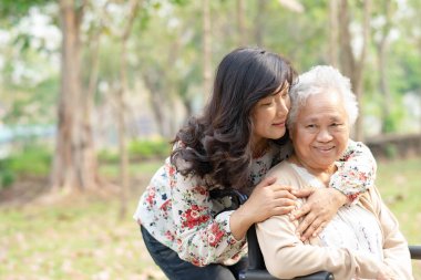 Hemşire hastanesi koğuşunda tekerlekli sandalyede oturan yaşlı kadın hastaya yardım ve bakım: sağlıklı güçlü tıbbi konsept