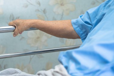 Asyalı yaşlı ya da yaşlı kadın hasta uzan. Yatağı umutla çek. Hastanedeki yatakta..