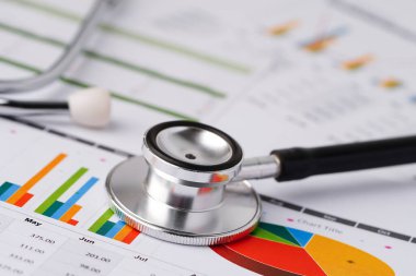 Çizelge ve grafikler üzerindeki steteskop tablo, finans, hesap, istatistik, yatırım, analitik araştırma veri ekonomisi ve işletme şirketi kavramı.