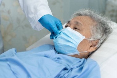Güvenlik enfeksiyonunu korumak ve Roman Coronavirus 'u (2019-nCoV) öldürmek için hastanede yüz maskesi takan Asyalı yaşlı ve yaşlı kadın hasta..