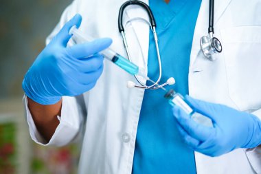 Doktorun elinde aşı geliştirme şırıngası var. Hastaların tedavisi için ilaç kullanılıyor. Novel Coronavirus (2019-nCoV) Covid-19 aşısı..