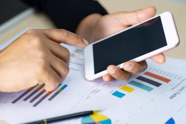 Modern ofisteki çalışma projesi için hesap makinesi ve grafik grafikli muhasebe basın telefonu.