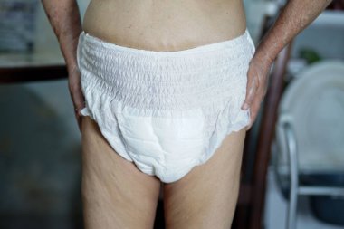 Hemşire koğuşunda idrarını tutamayan yaşlı kadın hasta: sağlıklı güçlü tıbbi konsept.  