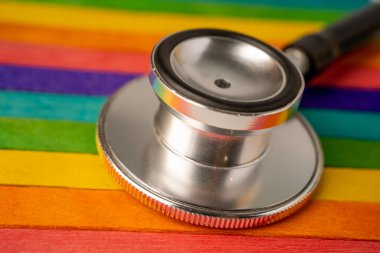 Lgbt bayrağı arkaplanındaki siyah steteskop: İş ve finans kavramı.