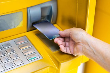 Asya 'lı yaşlı ya da yaşlı kadın para çekmek, kontrol etmek ya da transfer etmek için makinenin düğme numarasına basıyor.