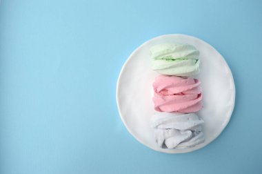 Ev yapımı tatlılar. Hatmi bir plaka üzerinde. Pembe bir arka plan üzerinde hassas Zephyr. Minimalist arka plan