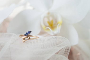 Beyaz zemin üzerinde mavi Zirkon taşlı altın yüzük