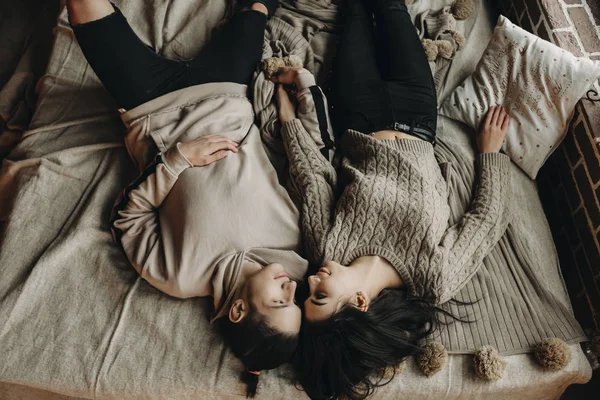 Erstaunliche junge Paar auf dem Bett liegend und einander anschauend. — Stockfoto