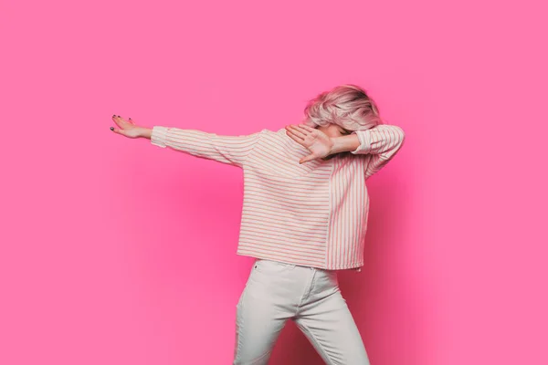 Гарний одягнений підліток жестикулює маззю, показуючи свою впевненість і виграшну позицію на рожевому тлі — стокове фото