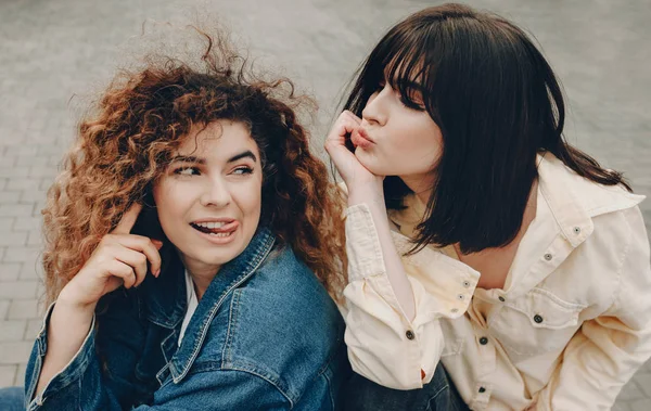 La vista superior de dos chicas expresivas con el pelo rizado que están posando fuera de pasar un buen rato juntos — Foto de Stock