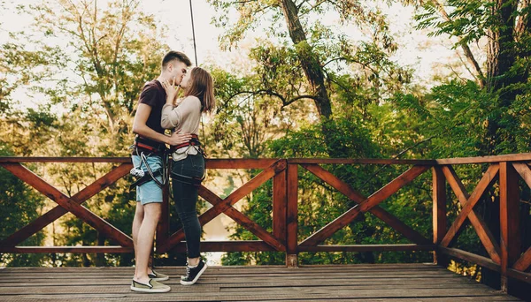 Två kaukasiska älskare kysser varandra innan de får en stor del av positiva känslor på en tyrolsk travers — Stockfoto