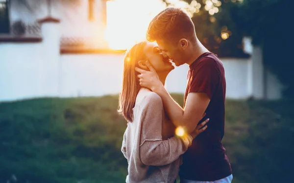 Två kaukasiska nygifta kyssas i ljuset av en gående nedåtgående sol som är glad för att tillbringa en hel dag tillsammans — Stockfoto