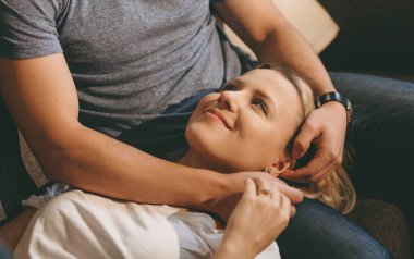 Erkek arkadaşının üzerine uzanan neşeli bir kadın ona bakıyor ve tekrar tekrar aşık oluyor.