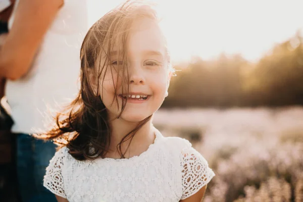 Uma foto com uma menina inocente posando com entusiasmo em um dia ensolarado de verão com o vento brincando em seu cabelo — Fotografia de Stock