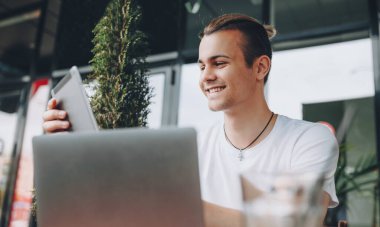 Beyaz tişört giyen ve çapraz zincirli beyaz bir çocuk aletleri üzerinde mutlu bir şekilde çalışıyor.