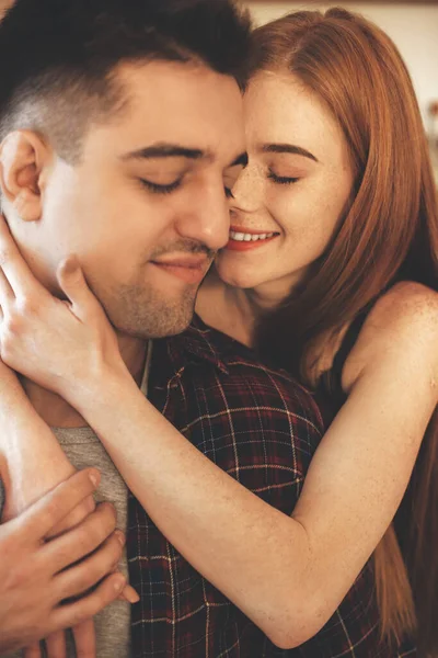 Ritratto ravvicinato di una coppia caucasica abbracciata ad occhi chiusi e bel sorriso di una donna dai capelli rossi con lentiggini — Foto Stock