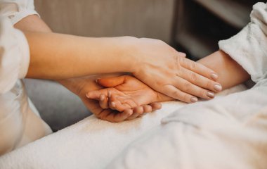 Dikkatli cildiyeciler müşterilerinin eline dokunur ve spa prosedürlerine hazırlar.