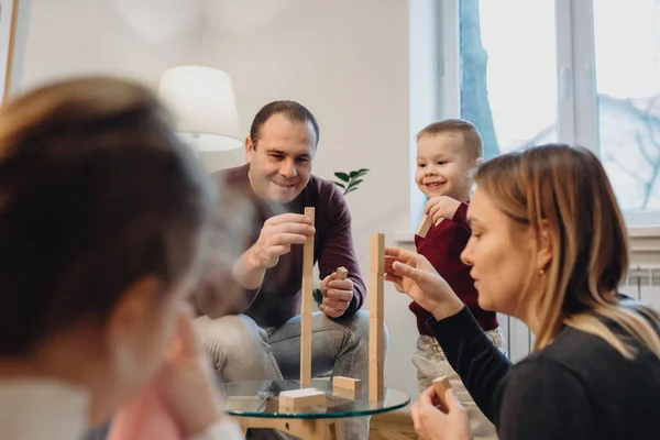 Famiglia caucasica in cerca di gioia e nuove emozioni stanno giocando a jenga con i loro figli — Foto Stock