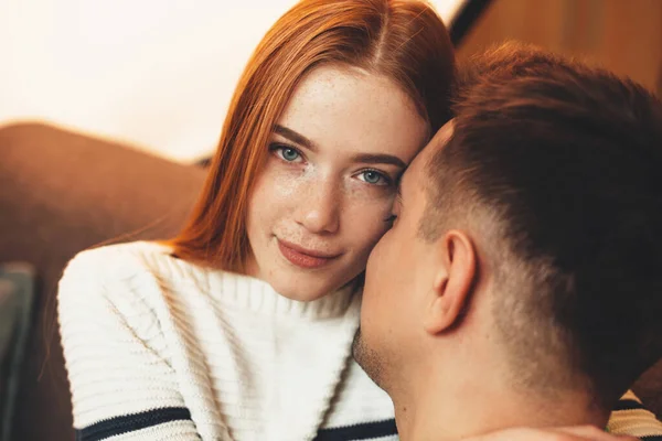 Splendida ragazza con lentiggini e capelli rossi sta guardando la fotocamera mentre abbraccia il suo amante bruna caucasica — Foto Stock