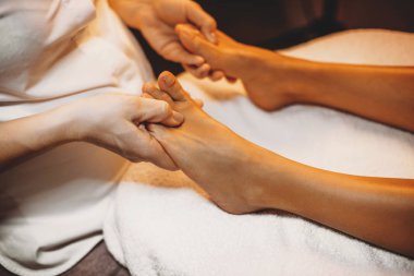 Kafkasyalı genç fizyoterapist spa ameliyatı sırasında hastaların bacaklarına masaj yapıyor.