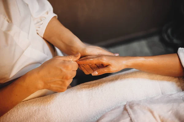 Mulher caucasiana tendo uma sessão de spa para os dedos da mão em um jovem terapeuta — Fotografia de Stock