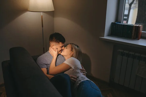 Bella ragazza caucasica con i capelli biondi sta baciando il suo amante mentre si tocca la guancia e sdraiato su di lui — Foto Stock