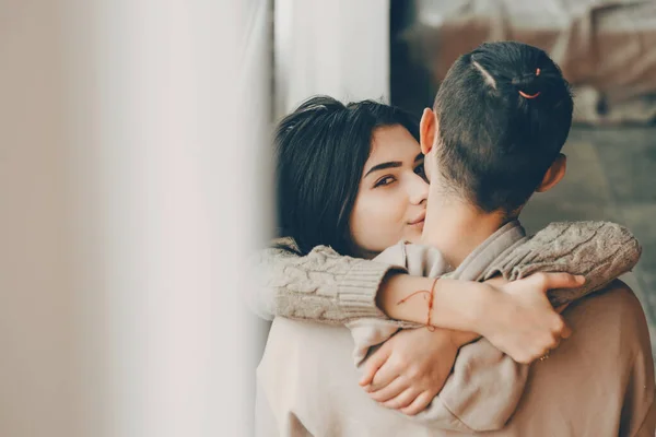 Svart hår dam tittar till kameran medan omfamna sin älskare i helgen morgon — Stockfoto