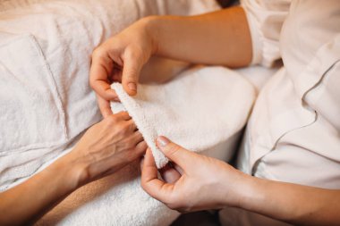 Kafkas spa uzmanı, cilt bakımı sırasında müşterilerin eline özel bir eldiven takıyor.