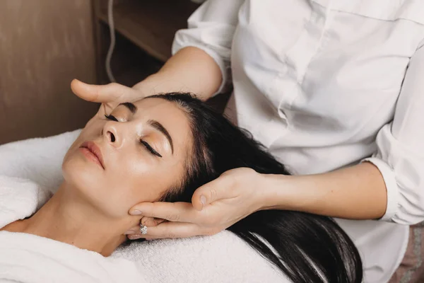 Caucasian woman lying on couch and having a spa procedure for her head and face
