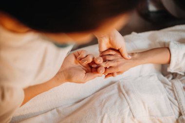 Profesyonel Kafkas spa çalışanı müşterilerine masaj yapıyor. O koltukta yatarken parmaklarını okşuyor.