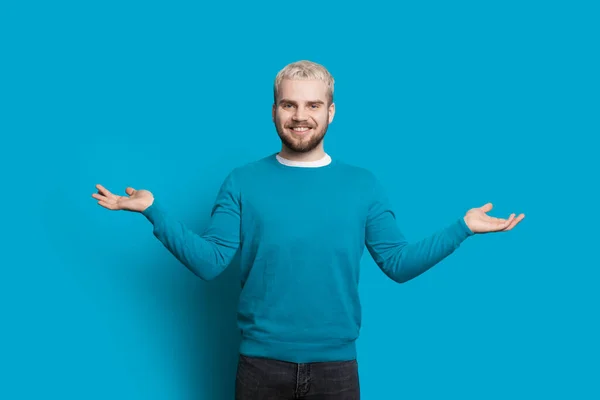 Blonde caucasiano homem com barba está gesticulando um equilíbrio enquanto posando em uma parede azul — Fotografia de Stock