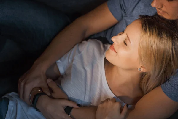 Joyeux couple caucasien embrasser et avoir de la joie ensemble tout en étant couché sur le canapé — Photo