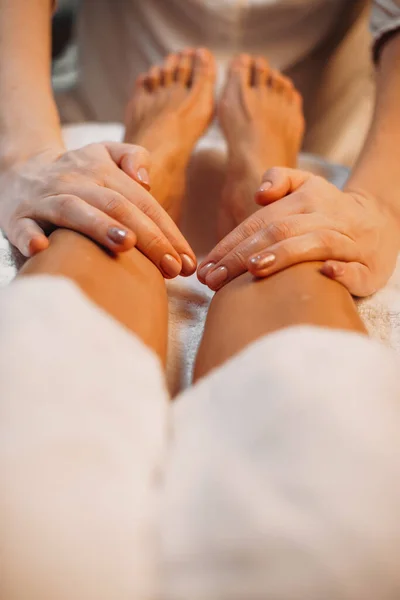 Närbild foto av spa massage session gjord av en noggrann arbetare på salongen på klientens ben — Stockfoto