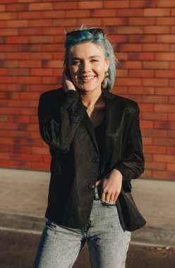 Kameraya bakarken arka planda mavi saçlı neşeli bir beyaz girişimci.